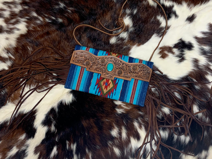 Saddle blanket crossbody purse with hand tooled leather and fringe.